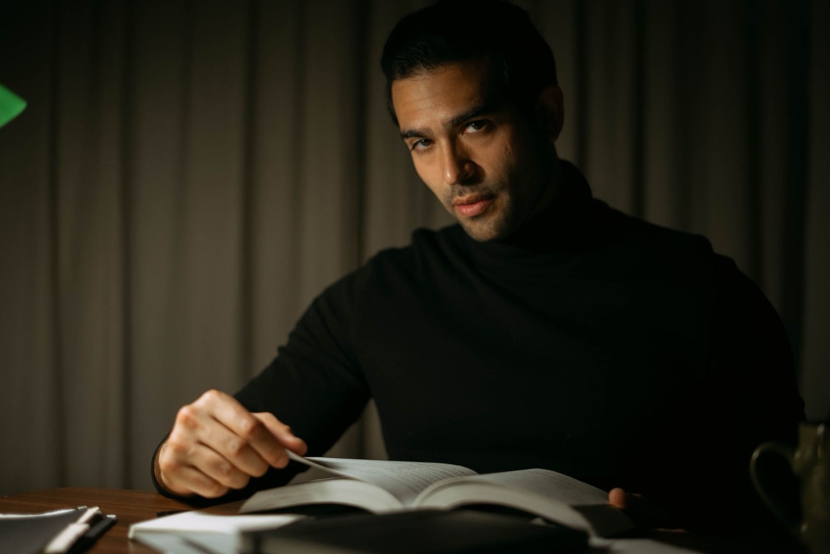 Persona leyendo con luz de lámpara de escritorio suave