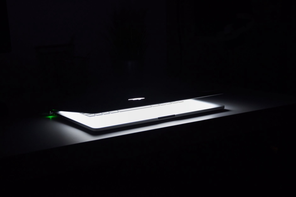 Comparaison de la luminosité d'un écran d'ordinateur portable dans une pièce sombre.