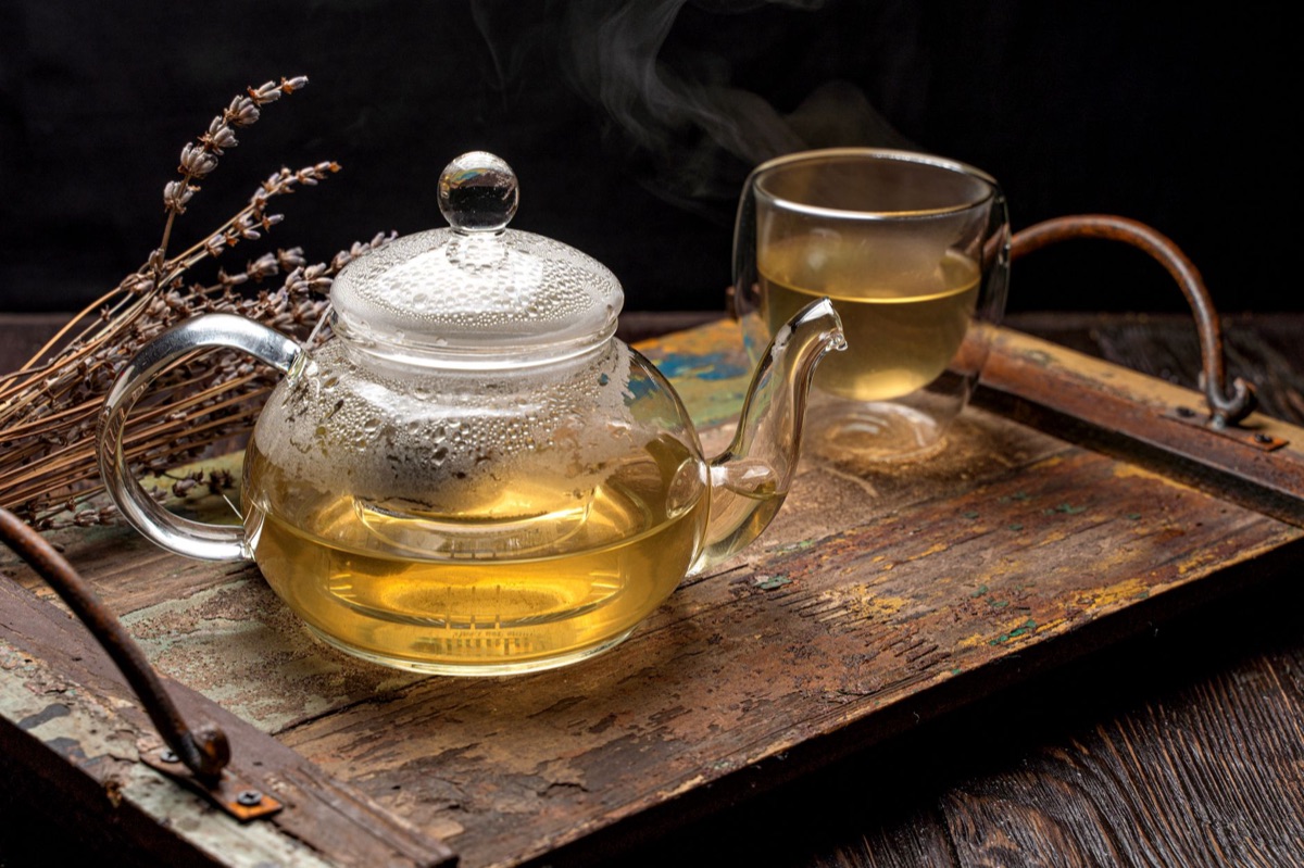 A steaming cup of herbal tea on a wooden table.