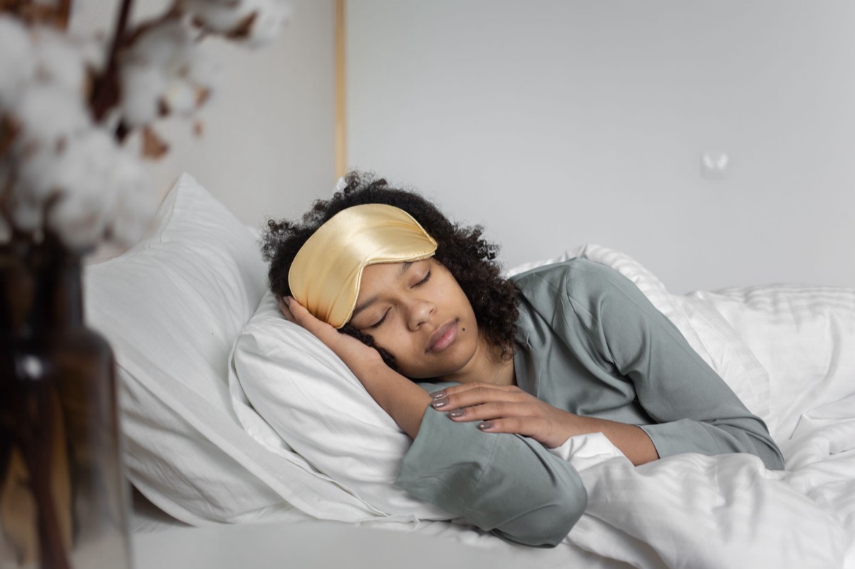 A silk eye mask resting on a clean linen pillow in soft morning light.