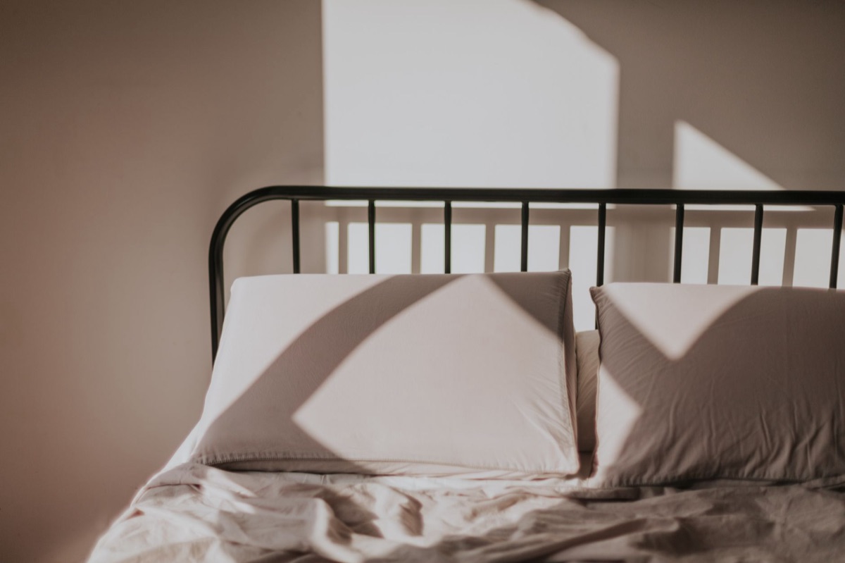 Ein aufgeschlagenes Buch auf einem Bett mit Leinenbettwäsche