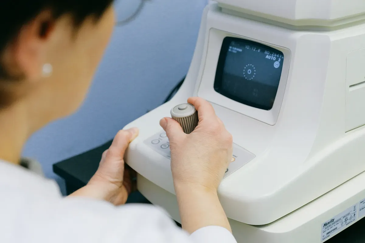 An optometrist operates an eye examination machine in a clinic setting, enhancing visual health care.