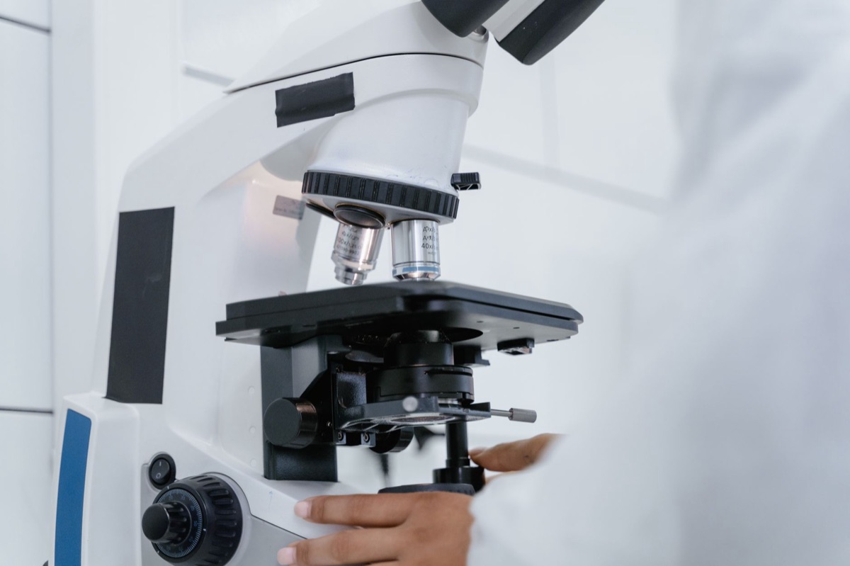 scientist in lab coat with microscope